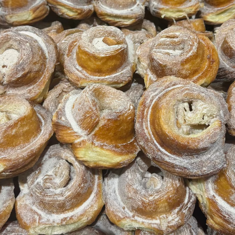Stack of round, baked goods with a golden brown crust on a gray surface.
